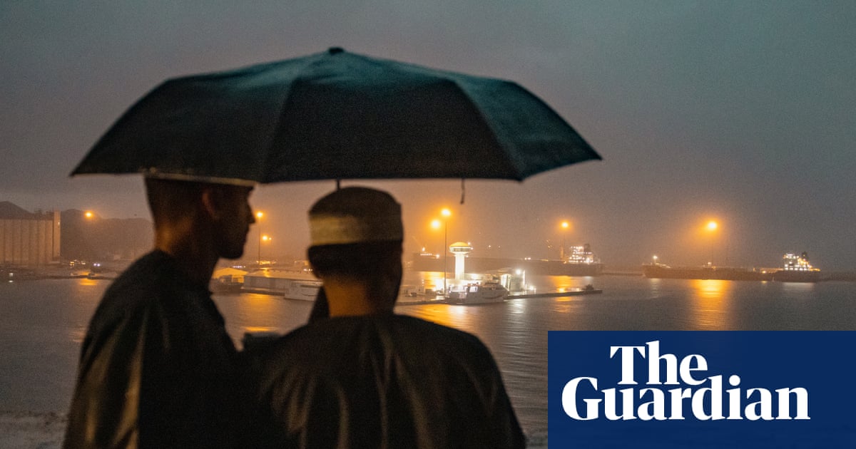 Oil refinery and tankers with smoke rising as Iran war drives crude to record monthly surge