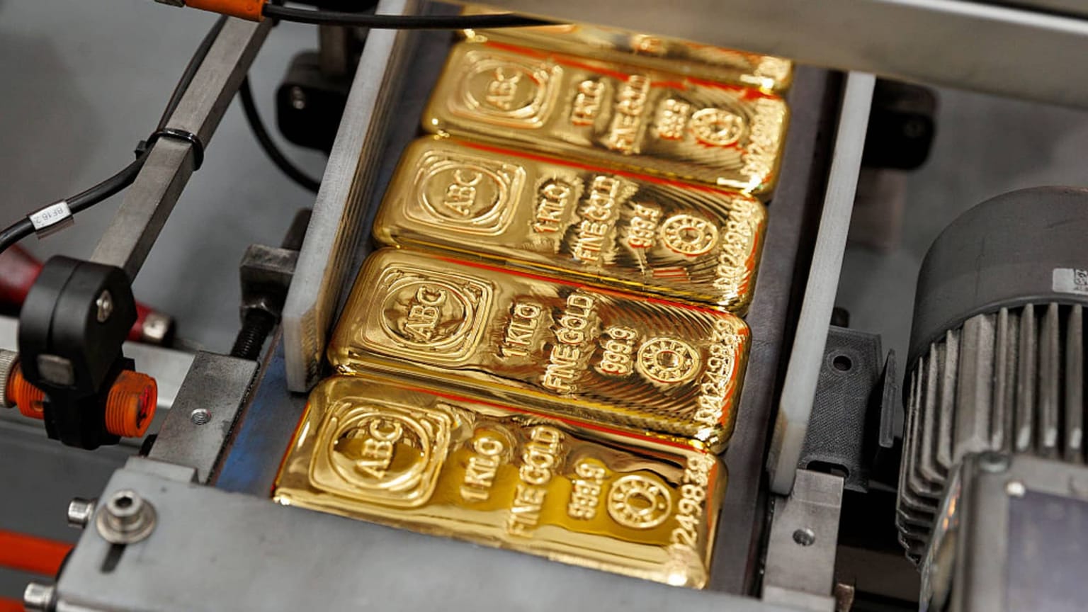 One-kilogram ABC Fine Gold 999.9 bars on a production line, used as the ThriveInMarkets evening-review hero for Friday August 28 2026, when spot gold dropped about 3 percent to near 4,460 dollars after Chair Kevin Warsh's first Jackson Hole keynote lifted September hike odds toward 58 percent and the S&P 500 closed 7,711.76