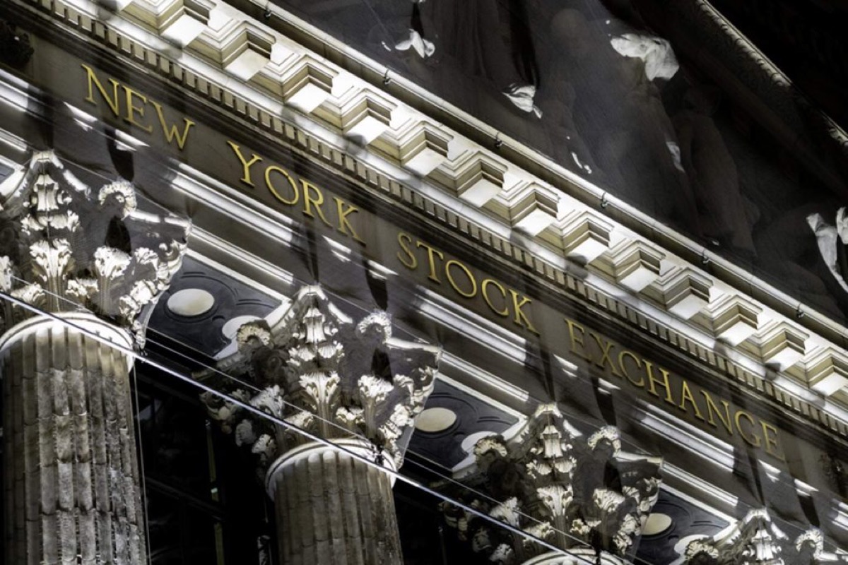 The New York Stock Exchange pediment and gold lettering on the Broad Street facade at night, used as the ThriveInMarkets evening-review hero for Tuesday October 13 2026, when the S&P 500 closed 7,805.45 down 0.02 percent, the Nasdaq Composite closed 27,204.38 down 0.15 percent, and West Texas Intermediate last printed about 94.90 dollars after reversing the morning fade
