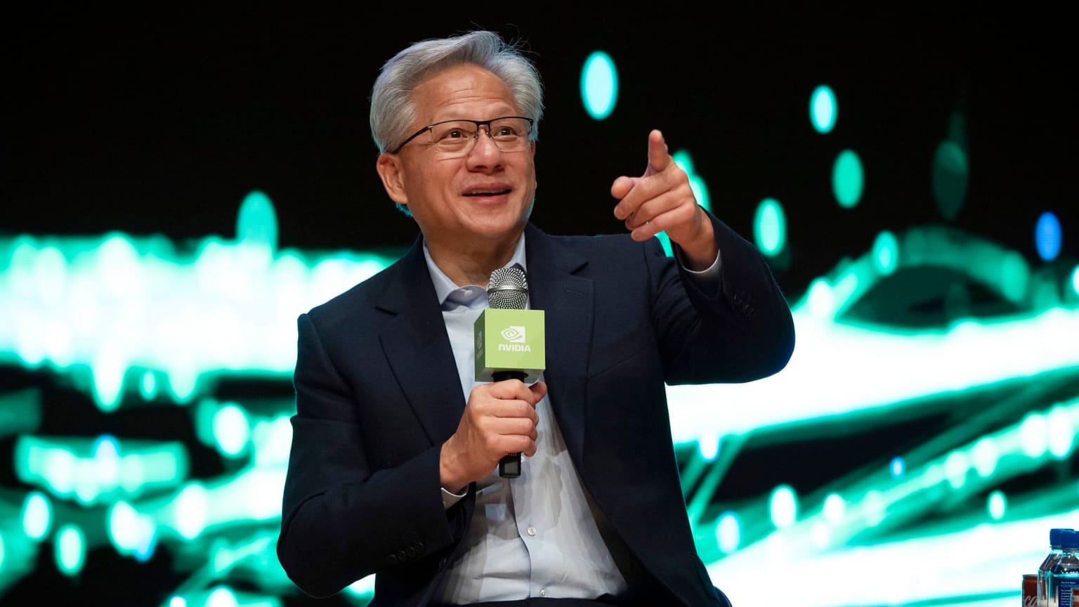 Photograph of Nvidia CEO Jensen Huang at an industry event illustrating the chipmaker's fiscal Q1 2027 earnings print on Wednesday May 20 2026 after the US market close, the single biggest single-stock catalyst of the second quarter, where Nvidia delivered revenue of 81.6 billion dollars beating the 79.2 billion dollar Street consensus with 1.87 dollars EPS versus 1.77 dollars expected, data center revenue of 75.2 billion dollars up 92 percent year-over-year, a Q2 guide of 89.1 to 92.8 billion dollars versus 87.3 billion dollars consensus, an 80 billion dollar share buyback authorization and a 25-fold quarterly dividend hike from 1 cent to 25 cents, yet the stock initially fell more than 2 percent in after-hours trading as expectations were sky-high heading into the print, the centerpiece of the ThriveInMarkets Thursday May 21 2026 morning analysis covering also the April FOMC minutes showing four dissents the highest count since October 1992, the S&P 500 closing at a 7,432.97 record up 1.08 percent on the pre-Nvidia rally, WTI crude diving 5.66 percent to 98.26 dollars on Iran de-escalation, Bitcoin holding 77,564 dollars and Ethereum at 2,132 dollars