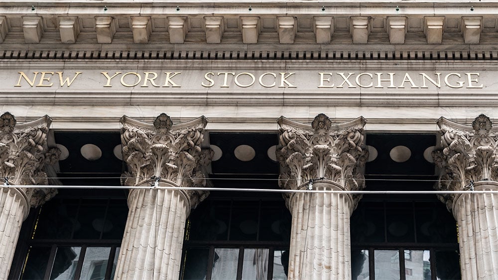 A Wall Street stock exchange trading floor under warm light, used in the ThriveInMarkets morning analysis for July 21 2026 as US equity futures point higher into a Fed-blackout earnings week headlined by Alphabet and Tesla reports on Wednesday