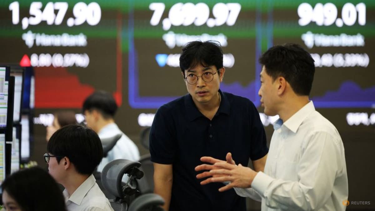 Currency dealers talk in front of Hana Bank boards showing USD/KRW, KOSPI and KOSDAQ at a Seoul bank dealing room, used as the ThriveInMarkets morning analysis hero for Thursday October 1 2026, when South Korea's September exports hit a record 120.9 billion dollars, the Kospi closed 6,971.35 up 1.95 percent, the Nikkei 225 closed 68,956.72 up 3.30 percent on Micron's beat, and overnight E-mini S&P 500 December futures sat near 7,763 against Wednesday's 7,651.54 cash close