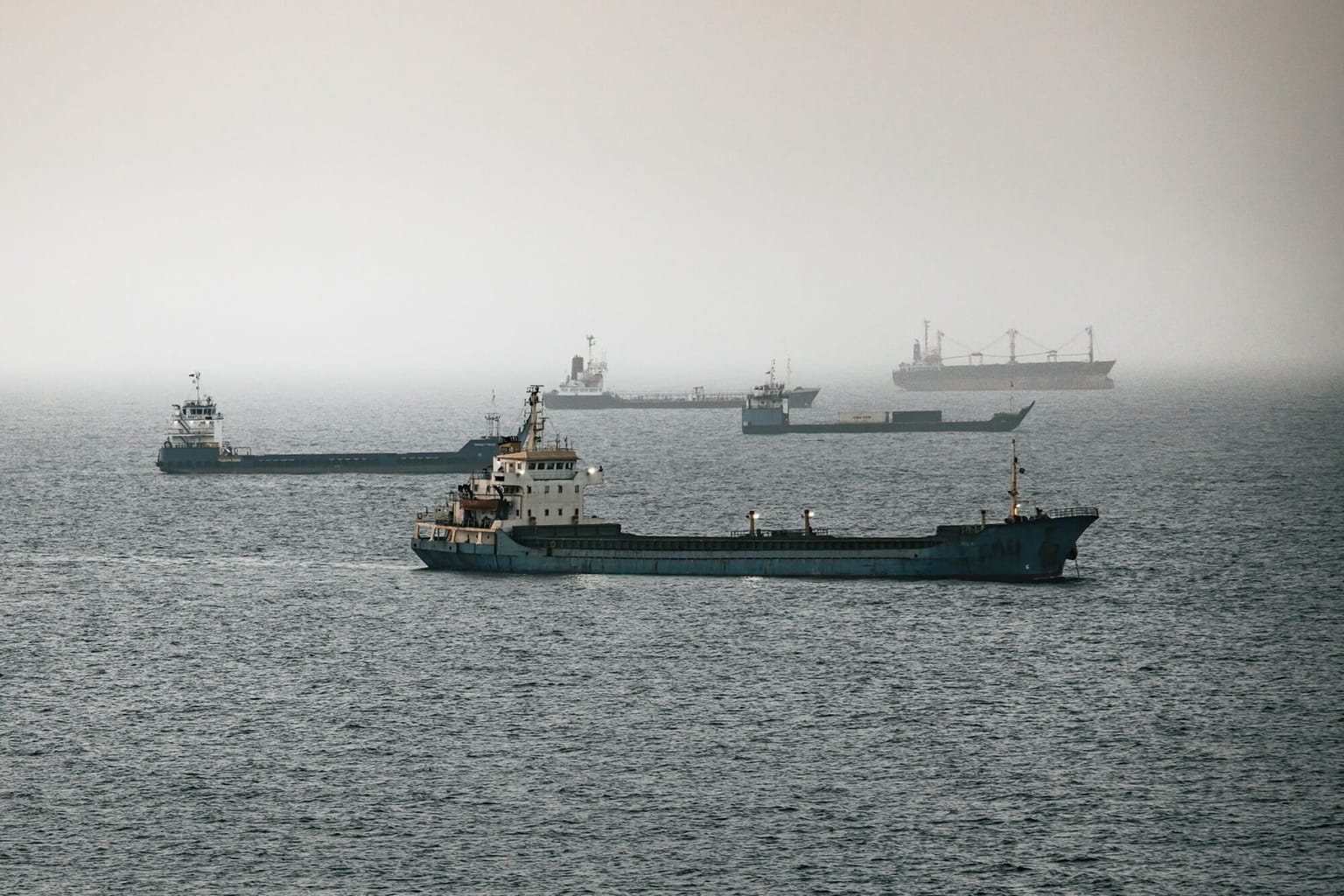 Crude oil tankers and bulk carriers at anchor off Muscat, Oman, used as ThriveInMarkets morning analysis hero for Monday October 12 2026, when WTI last printed about 90.90 dollars after Trump claimed a Russia-Ukraine energy ceasefire, Brent held near 104 dollars, and Hormuz tanker attacks continued over the weekend