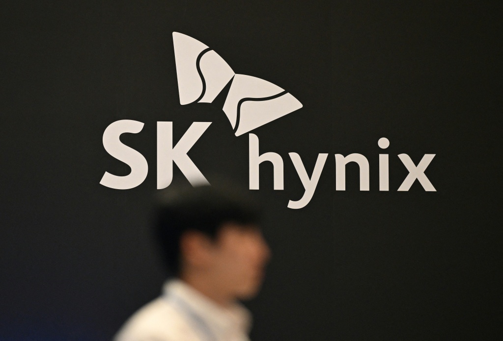 SK hynix logo on a dark wall as a pedestrian walks past, used as the ThriveInMarkets morning analysis hero for Tuesday October 13 2026, when South Korea's Kospi closed 6,035.35 down 5.5 percent and SK Hynix fell about 10 percent